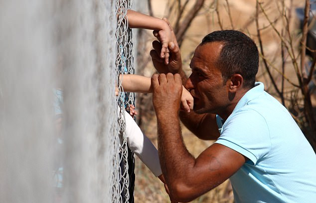 nguoi cha syria hon cac con qua hang rao sat khi ho duoc doan tu sau 1 nam xa cach vi khoi lua chien tranh