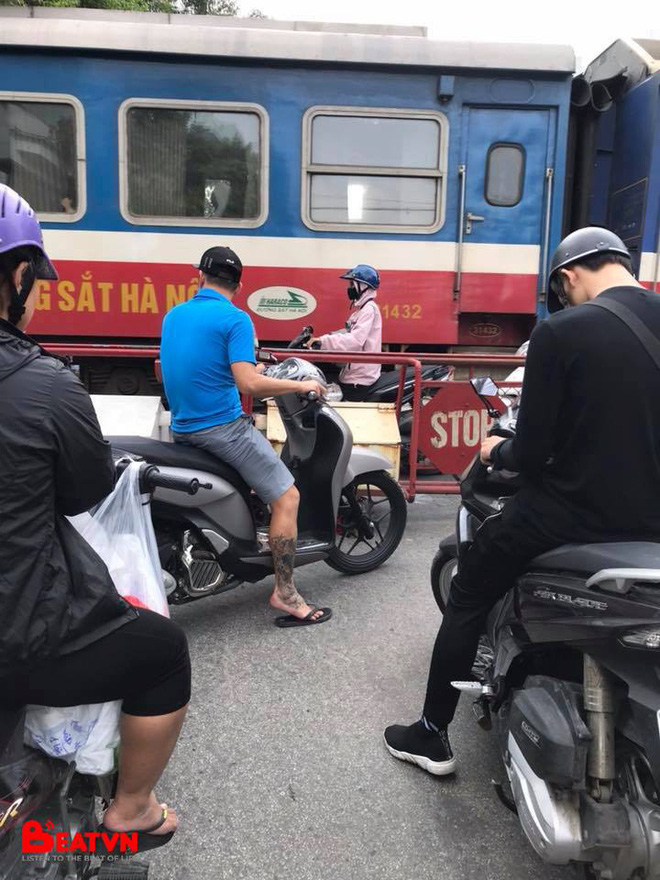 buc anh gay cang thang co gai di xe may dung trong khe hep giua doan tau dang chay va rao chan