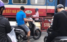 buc anh gay cang thang co gai di xe may dung trong khe hep giua doan tau dang chay va rao chan