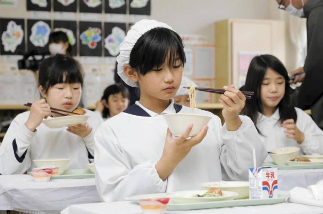 Học sinh Nhật Bản thích thú thưởng thức mòn ăn đặc sản của cố đô Huế. Ảnh: Ehime Shimbun